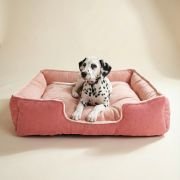 small dog using side bolsters as armrests in lounger dog bed
