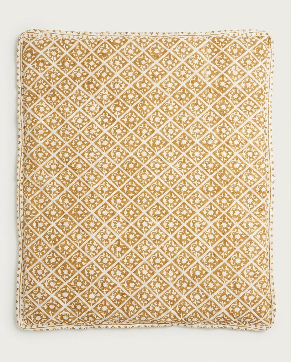 cotton pet blanket draped over bolster dog bed